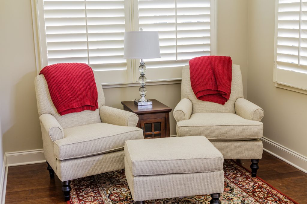 Cozy reading nook with two armchairs draped in red blankets